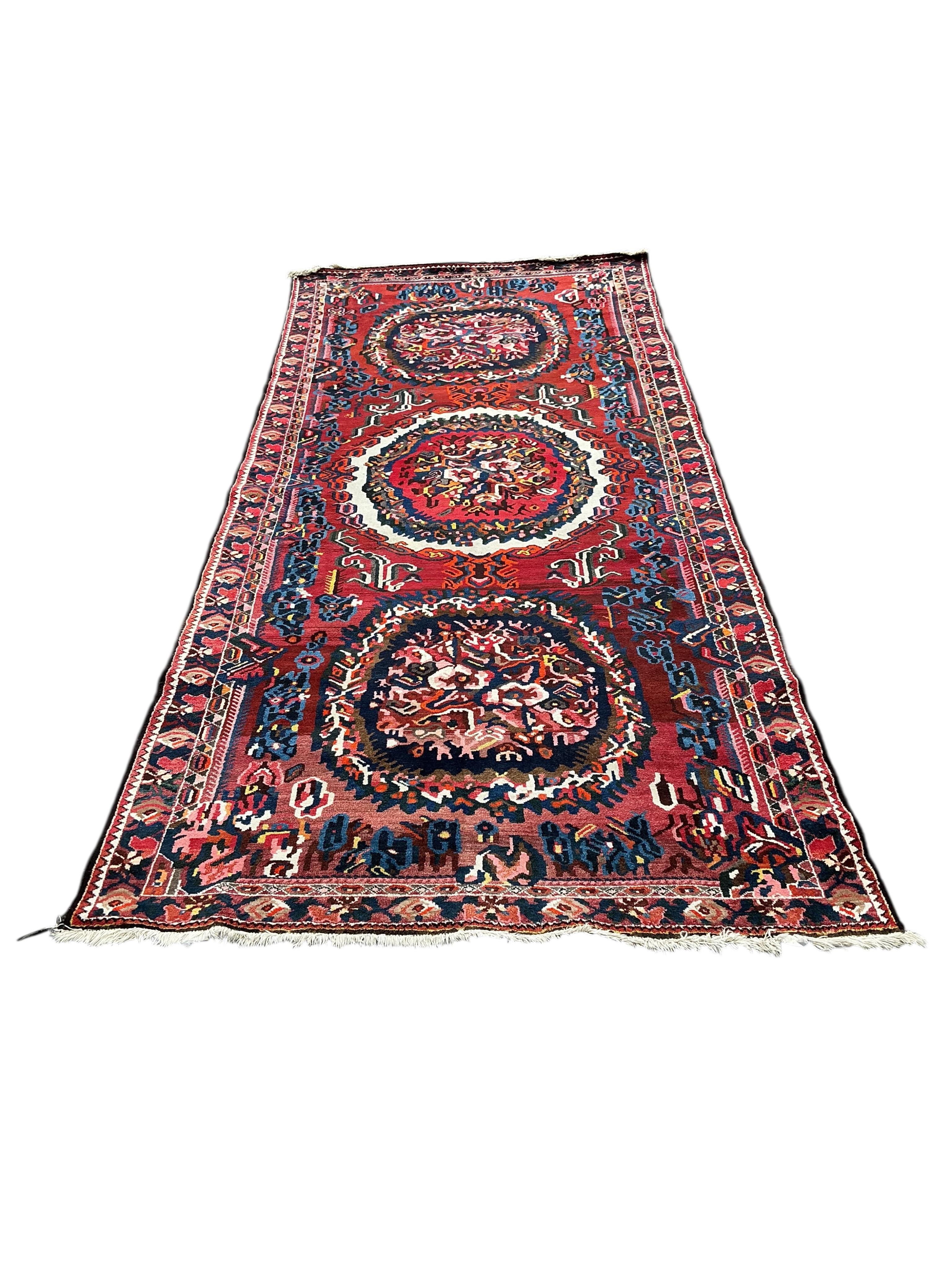 A Baktiari red ground carpet, 390 x 170cm